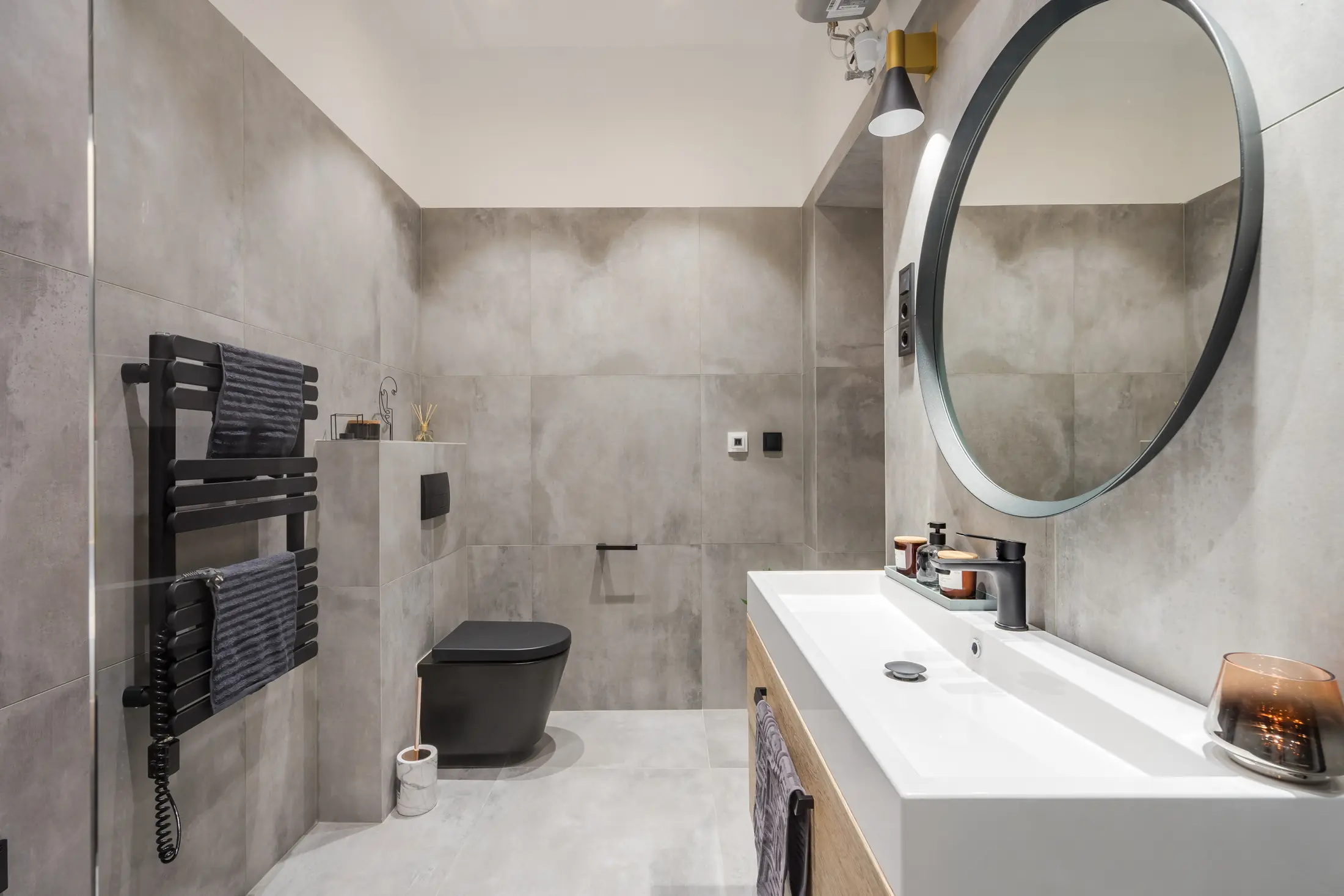 Salle de bain livrée vue depuis la douche avec meuble vasque et sèche-serviettes