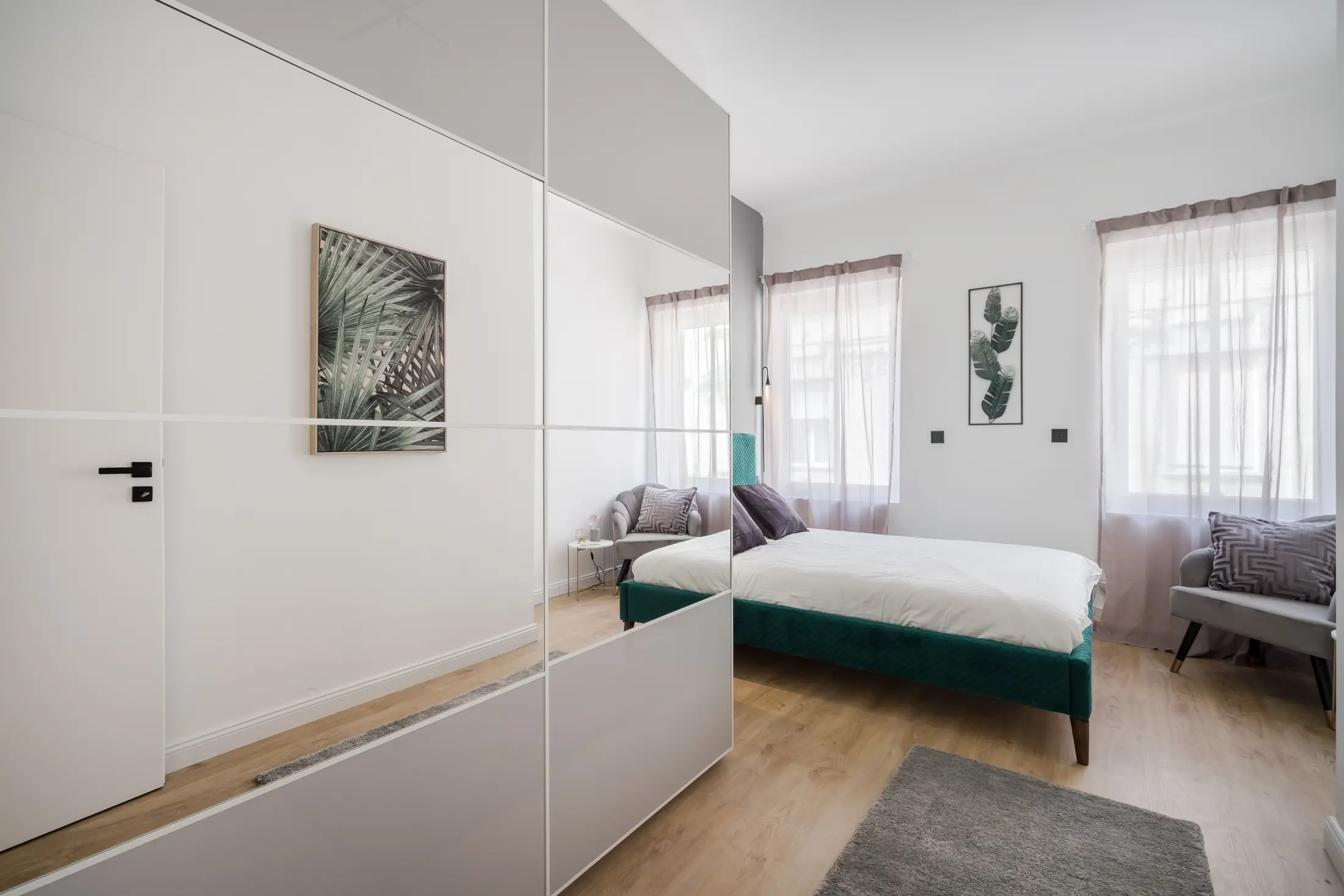 Chambre livrée avec lit vert et grande armoire miroir